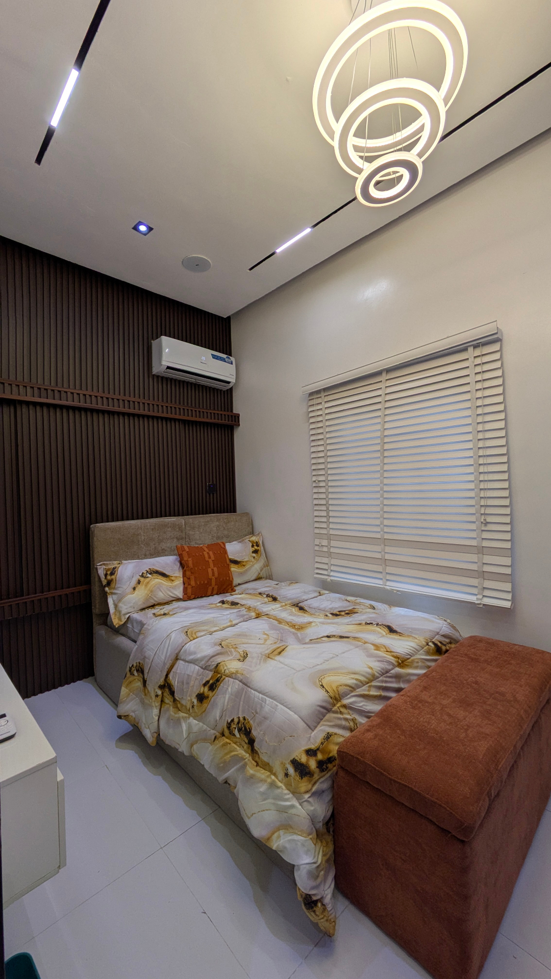 Third bedroom with gold marble bedding and ring chandelier