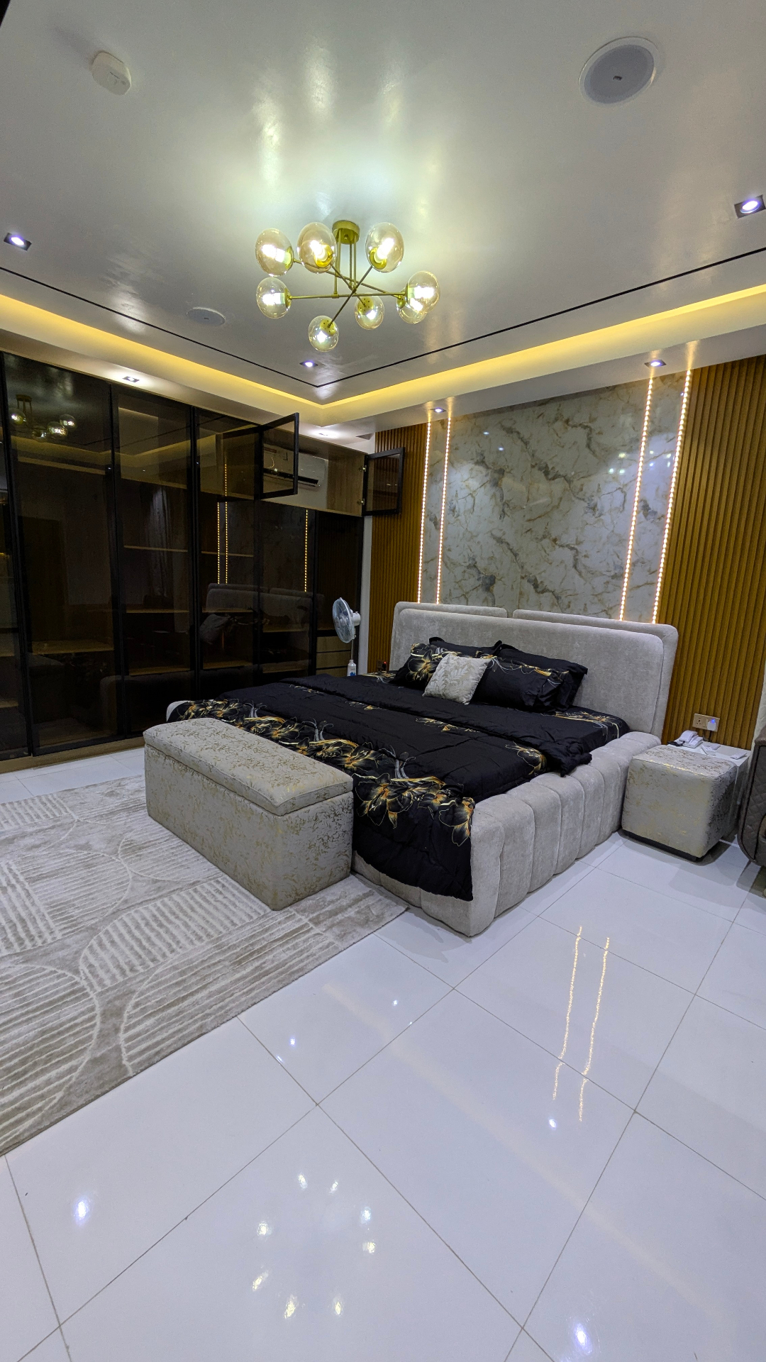 Master bedroom with mood lighting and marble accent wall